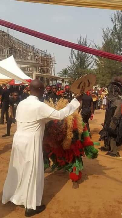 Nigerian Catholic Priest dancing with Masquerade